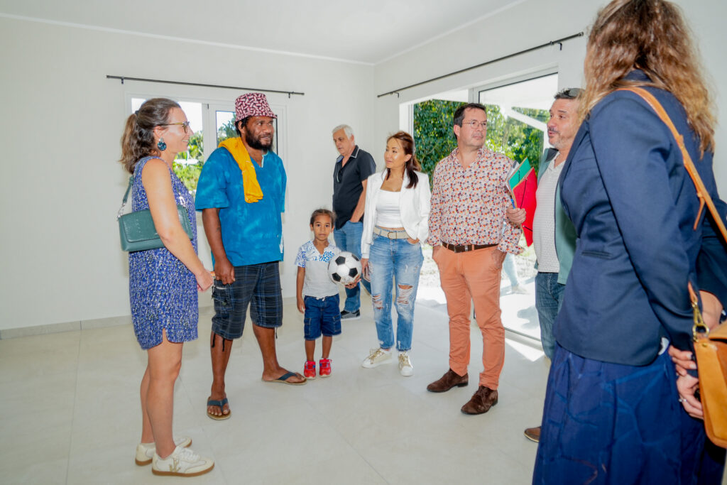 Group of diverse adults and a child standing in a bright modern room chatting the child holds a soccer ball