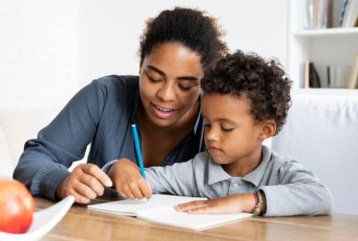 Une maman enseigne l'écriture à son fils